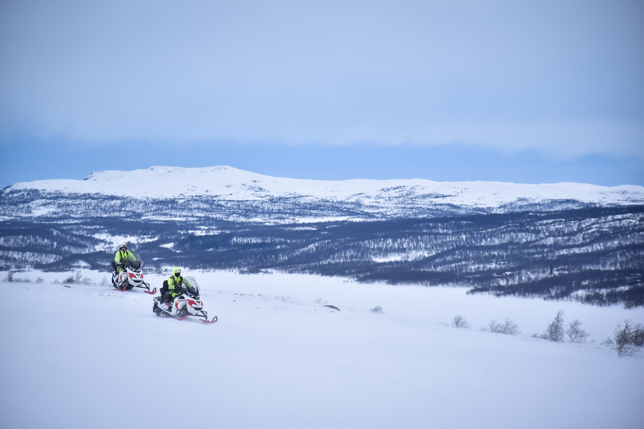 Två personer som kör elsnöskoter